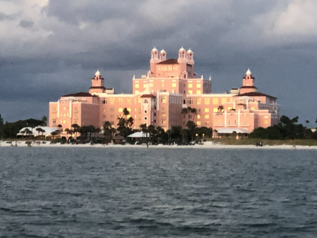 A large, historic waterfront hotel illuminated at twilight.