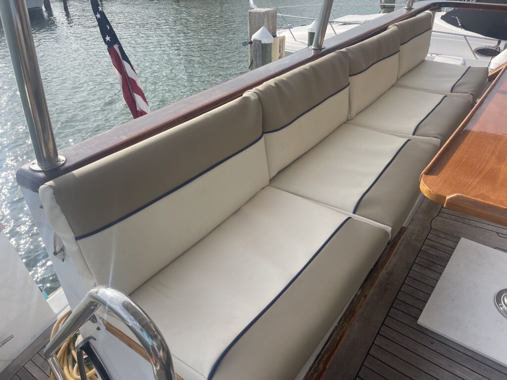 Luxury yacht rentals seating with cream and navy upholstery near a calm waterfront in Tampa.