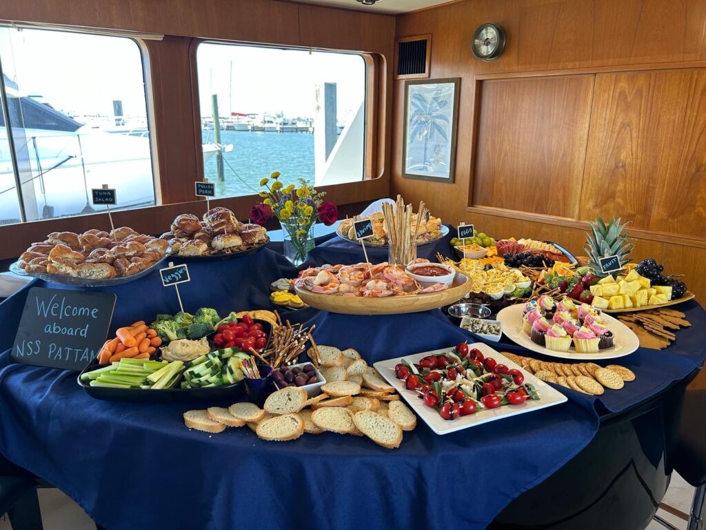 An array of appetizers and desserts elegantly presented on a yacht.